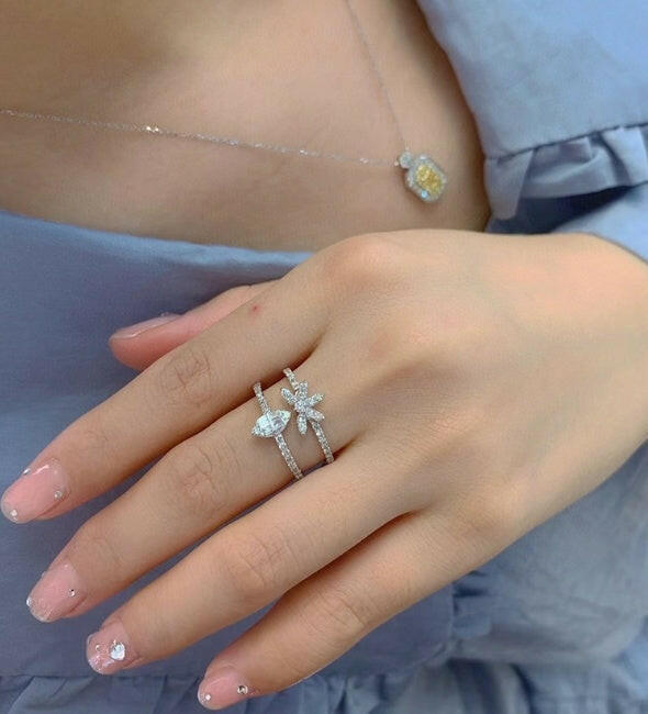 Elegant three-layer zircon ring featured on a hand, complementing a delicate necklace